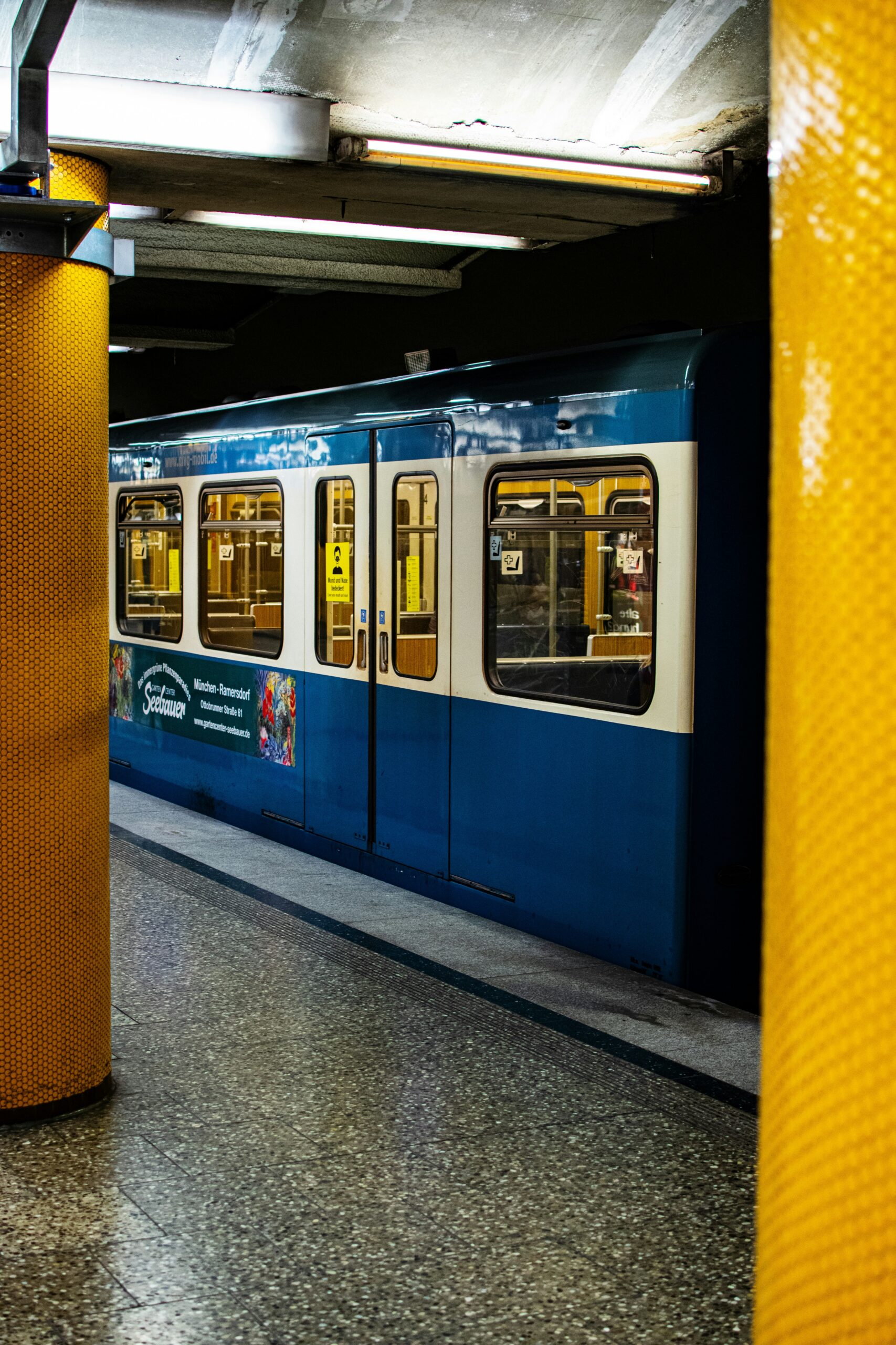 Außenaufnahme einer U-Bahn in München. Zu sehen sind außerdem zwei Säulen der U-Bahnstation.