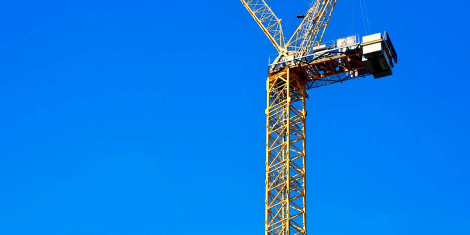 Aufnahme von einem gelben Kran vor einem wolkenlosen Himmel