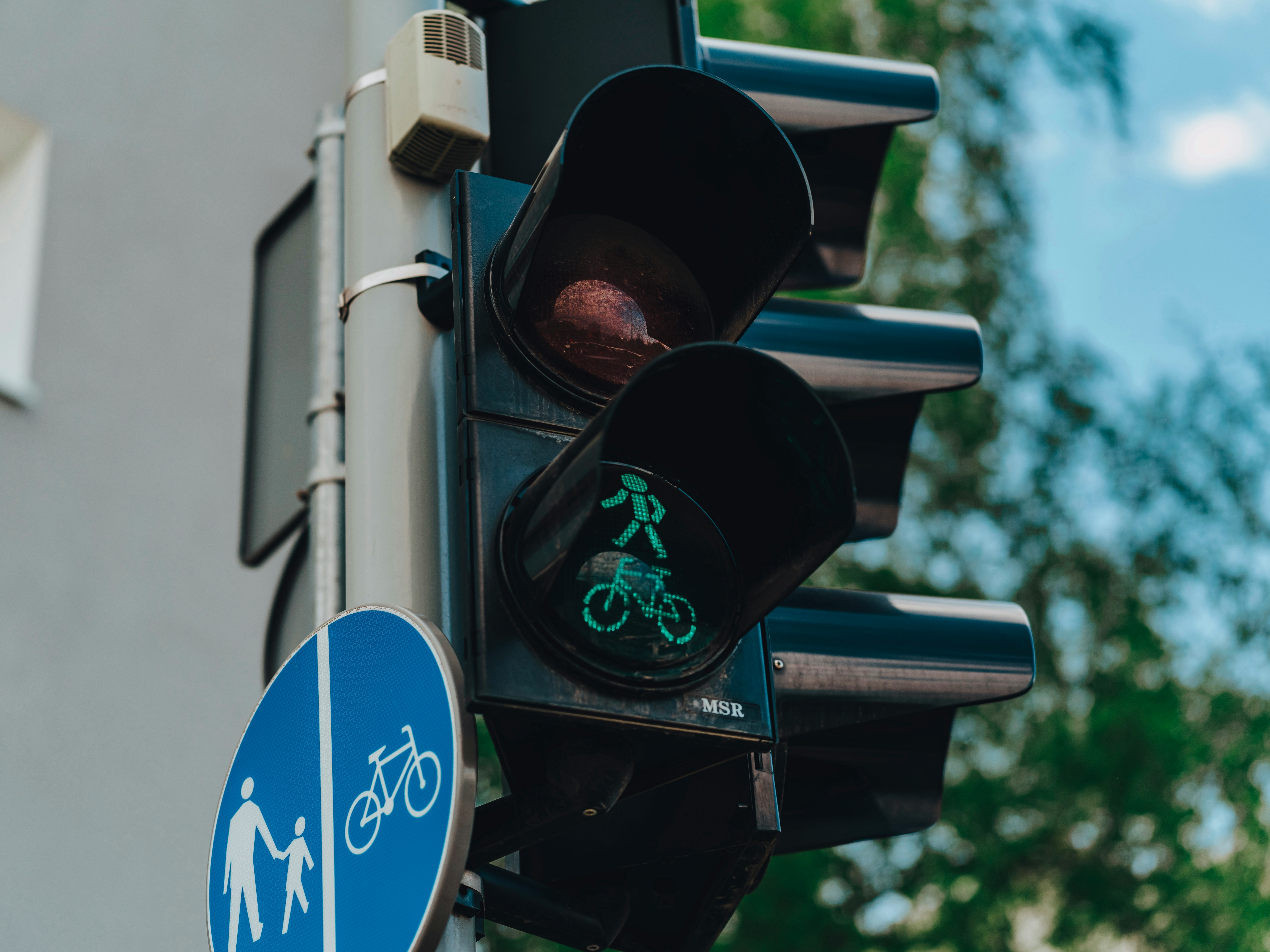 Aufnahme von einem Verkehrsschild und einer Ampel für Fahrradfahrer*innen und Fußgänger*innen